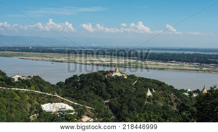 High angle view of multiple temples and pagodas on the mountains with Irrawaddy river in the background from sagaing hill, Sagaing region of Myanmar.