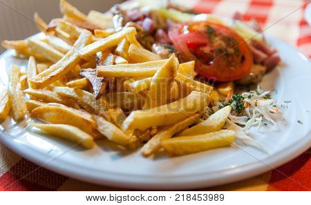 Straw potatoes , chicken breast , healthy vegetables on plate.