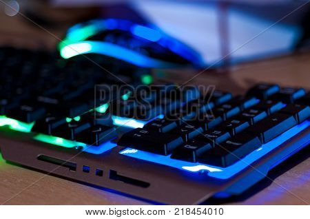 Colorful gaming keyboard, gaming mouse in background.
