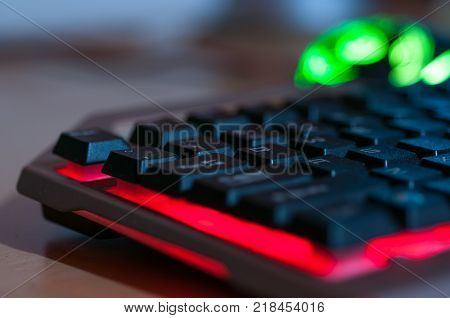 Colorful gaming keyboard, gaming mouse in background.