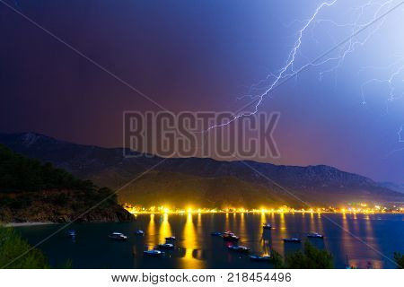 Lightning in the night sky under Adrasan bay. Adrasan village location, District of Kemer, Antalya Province, Turkey. Artistic style post processed photo.