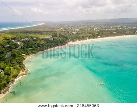 An aerial view of Byron Bay on a clear day with blue water