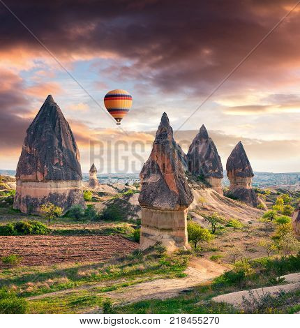 Unreal world of Cappadocia. Sunrise in Red Rose valley in April. Cavusin village located district of Avanos in Nevsehir Province in the Cappadocia region of Turkey Asia.