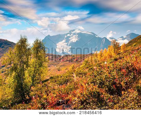 Colorful autumn landscape in the Caucasus mountains. Sunny morning viev of Mkheer mountain in the mist Upper Svaneti Georgia Europe. Artistic style post processed photo.