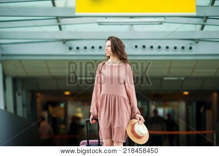 Young woman in international airport walking with her luggage.