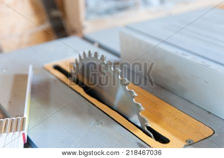 Table saw blade close up shot in a small workshop.