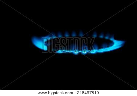 Gas stove blue light isolated on black, close up shot.