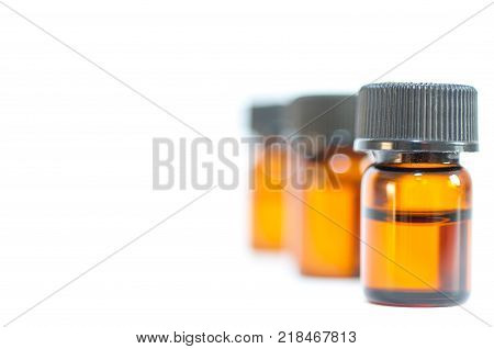 Tiny little brown medical bottles close up shot isolated on white background.