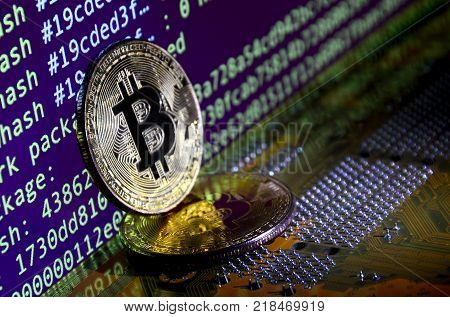 The digital process of cryptocurrency mining by using the GPUs. Bitcoins and video card on a working display and mining screen