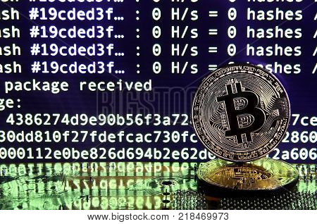 The digital process of cryptocurrency mining by using the GPUs. Bitcoins and video card on a working display and mining screen