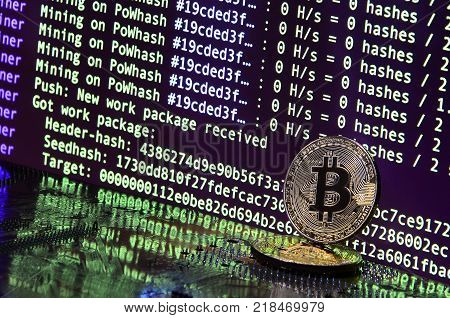 The digital process of cryptocurrency mining by using the GPUs. Bitcoins and video card on a working display and mining screen