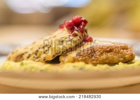 Meat patties or frikadeller in chese and mushroom sauce decorated with berries