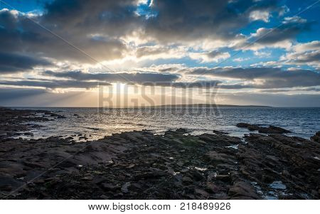 Coastline sunset dusk, Scotland and the Orkneys. A dusky sunset view from John O'Groats the most north-easterly point of the UK mainland with the island of Stroma visible in the distance.