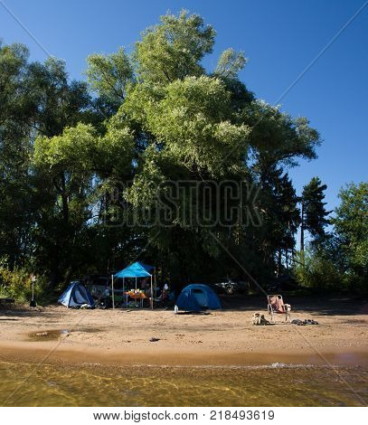 The tent city under the trees by the river
