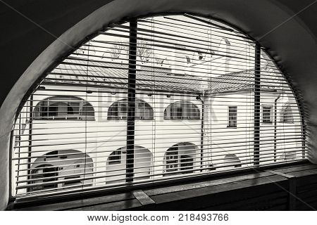 Courtyard of Strazky chateau from arc window Slovak republic. Cultural heritage. Architectural theme. Black and white photo.