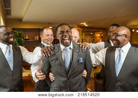 Portrait African American groom and groomsmen smiling.