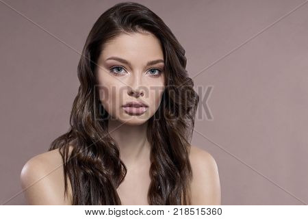 Young and healthy woman with light make-up on beige background. Natural beauty and skin care concept.
