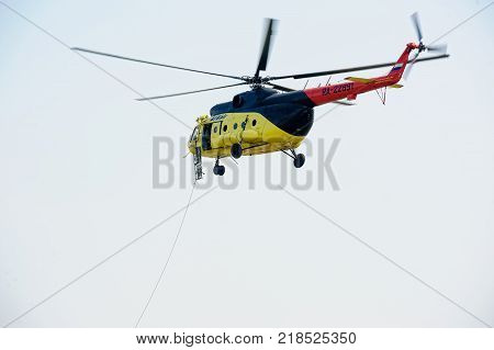 Tyumen, Russia - August 11, 2012: On a visit at UTair airshow in Plehanovo heliport. Rescuers lower stretcher from MI-8 helicopter for raising of injured person
