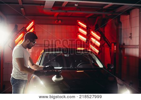 Car polish wax. worker hands holding a polisher and polish car