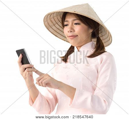 beautiful woman in pink dress and vietnam hat holding smartphone. isolated background with clipping path.
