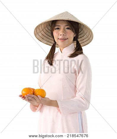 beautiful woman in pink dress and vietnam hat holding orange. isolated background with clipping path.