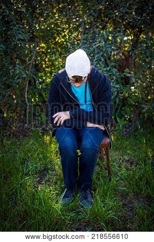 Sad Teenager sit on the Chair on the Nature Background
