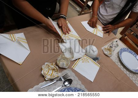 Asian women are practice folding the fabric nepkin.Thailand.