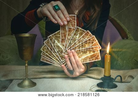 Tarot cards on fortune teller desk table. Future reading. Woman fortune teller holding and hands a deck of tarot cards.