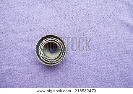 Toothed spiked nozzle for a drill for cutting circles in a tree on a purple background. Wood cutting nozzle.