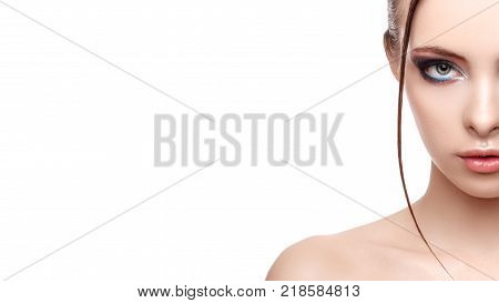 Close up half face portrait of model with glamorous makeup wet effect on her face and body high fashion and beauty creative makeup theme strobing or highlighting makeup copy space your text here
