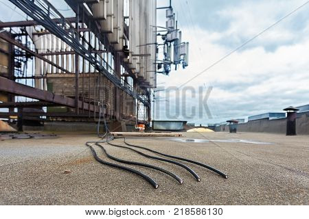 Four black coaxial cables for telecommunication wireless communication systems are cut by vandals on the roof. Cutting and breaking cables vandalism concept.