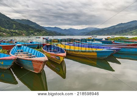 POKHARA NEPAL - September 29 2013: Old small boats on the Phewa lake. Rowboat symbol of Phewa lakeside in Pokhara city.