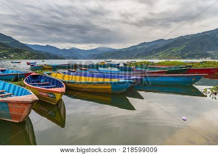POKHARA NEPAL - September 29 2013: Old small boats on the Phewa lake. Rowboat symbol of Phewa lakeside in Pokhara city.