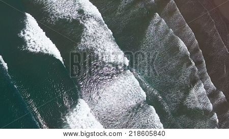 Top aerial view frop drone of Tropical exotic beach with volcanic sand in Bali, Indonesia