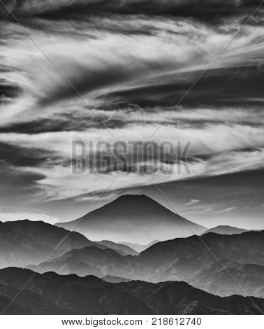 Iconic Mount Fuji wrapped in misty clouds like and old painting seen from Mount Takao in Japan (Black and White)