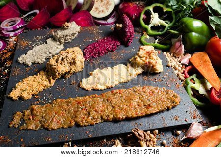 Pkhali ethnic Georgian cuisine meal of minced vegetables and nuts. Creative food serving with vegetable background.