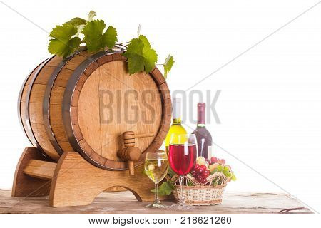 Grapes and bottels of wine near the wooden barrel. Glasses of wine on the table, concept of winery - red and white