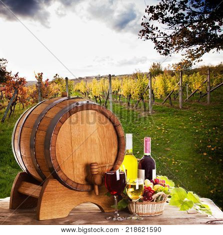 Grapes and bottels of wine near the wooden barrel. Glasses of wine on the table, concept of winery - red and white