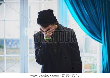 Teen covered his face, peeking through his fingers at interior