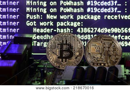 The digital process of cryptocurrency mining by using the GPUs. Bitcoins and video card on a working display and mining screen