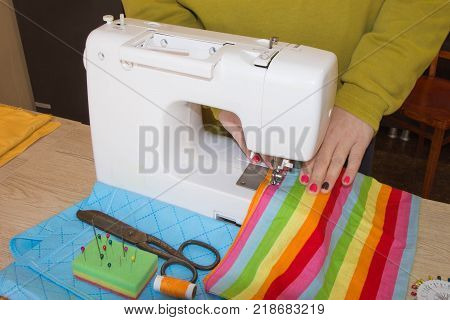 Sewing machine.sewing process in the phase of overstitching. Dressmaker work on the sewing machine.Tailor making a garment in workplace. Hobby sewing fabric as a small business concept