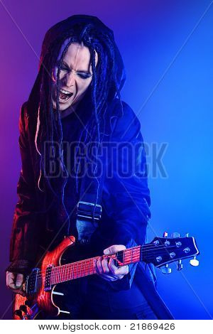 Heavy metal musiker spiller elektrisk guitar. Skudt i et studie.