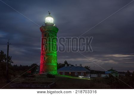 Lighthouse and house in the Baltic Sea. Shore, evening light, sunset, clouds and architecture concept. Mohni, small island in Estonia, Europe.