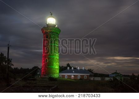 Lighthouse and house in the Baltic Sea. Shore, evening light, sunset, clouds and architecture concept. Mohni, small island in Estonia, Europe.