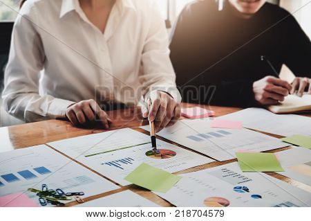 Young Business Woman Holding A Pen Pointing The Graph And Partnership To Analyze The Marketing Plan 