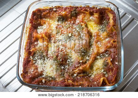 lasagna at basil pesto sauce baked in glass pyrex dish