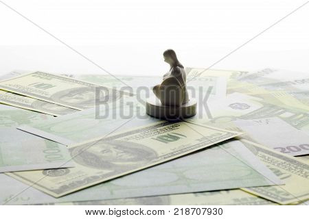 chess piece of a pawn in armor in the form of a figure of a man sitting on his knee on banknotes . worship or money or business concept