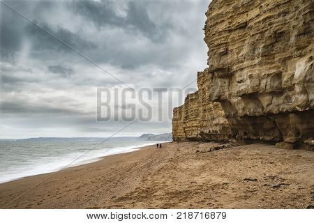Beautiful Vibrant Sunset Landscape Image Of Burton Bradstock Golden Cliffs In Dorest England