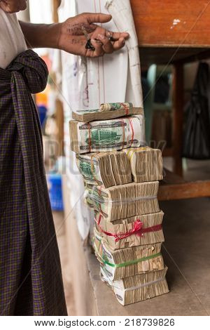 Hpa-An, Myanmar - October 21, 2017: Stacks of Myanmar money kyats in illegal exchange point on the border of Burma