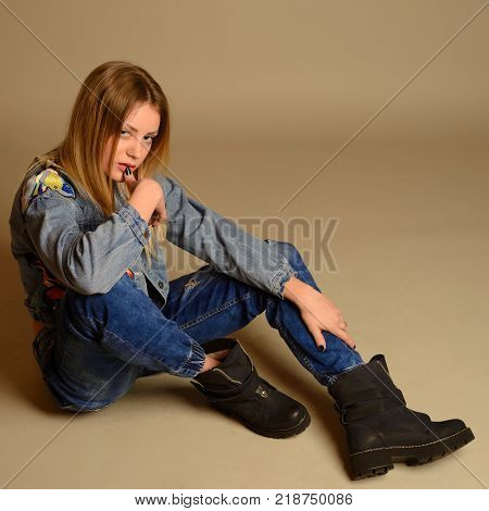 Teenage Girl Sitting On The Floor Showing The Tongue